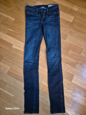 Diesel Skinzee skinny jeans blå - Snygga blå Diesel Skinzee jeans i super slim-skinny modell med regular waist. Jeansen har klassisk femficksdesign, stretchigt material och smal passform som sitter tajt hela vägen ner. Perfekta för dig som gillar en modern och stilren look.