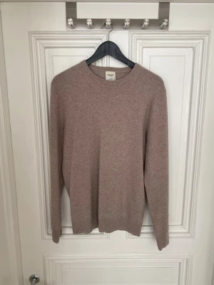 Beige kashmirtröja från John Henric - Snygg beige tröja från John Henric i mjuk kashmir. Klassisk rund hals och långärmad modell med ribbade muddar vid ärmslut och nederkant. Perfekt för dig som gillar stilrena och sköna plagg med lyxig känsla.