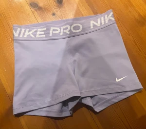 Ljuslila Nike Pro träningsshorts - Ljuslila hotpants i ett väldigt fint skick. Använda 2 gånger. Ser helt nya ut. Lappen på insidan håller på att gå av men det är ingen viktig lapp. Nypris 350 kr. 