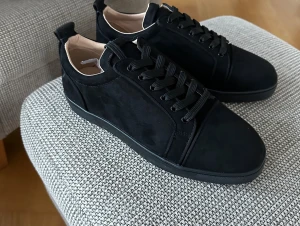 Christian Louboutin svarta sneakers - Säljer ett par svarta sneakers från Christian Louboutin i mocka med klassisk röd sula. Pris kan diskuteras! 