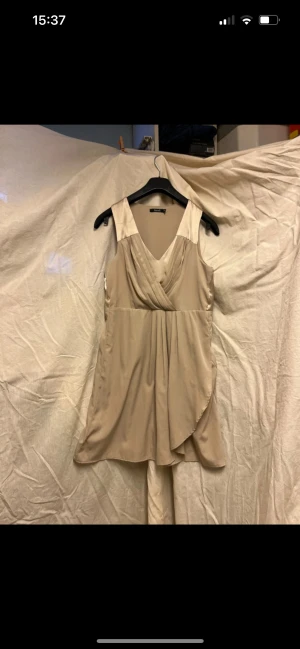 Beige festklänning  - Beige fedtklänning. 90 cm från axeln. 