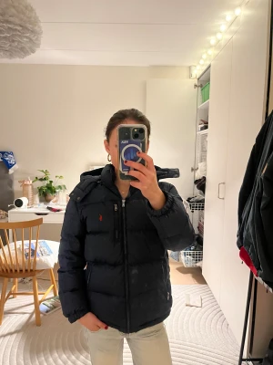 Mörkblå pufferjacka Polo Ralph Lauren - Snygg Ralph Lauren vinter jacka! Säljer pga den blivit för liten. Lite smink defekter vid kragen, ska prova att tvätta. Tyvärr står även mitt namn samt nummer på lappen innuti jackan, men det tänker man inte på samt går att stryka över! Köpt på kidsbrandstore, storlek L(ålder 14-16) och sitter som en XS.  Nypris 3295❤️ Skriv gärna vid frågor!