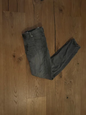Gråa slim fit jack and jones jeans - Ett par slim fit jack and jones jeans.