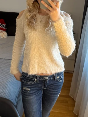 Offshoulder fluffig beige tröja från Lindex - Supermjuk och fluffig beige tröja från Lindex med offshoulder-detalj. Tröjan har lång ärm och rund halsringning, perfekt för dig som gillar en cozy och trendig look. 