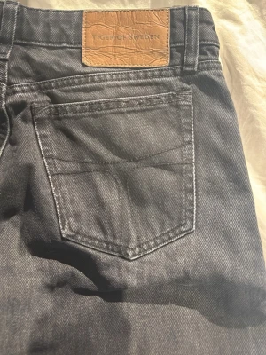 Svarta jeans från Tiger of Sweden, Lore - Svarta jeans från Tiger of Sweden i modellen Lore. Jeansen har raka ben och klassisk femficksdesign med läderpatch bak i midjan. Materialet är robust denim i bomull och passformen är normal. Perfekt för dig som gillar stilrena och tidlösa jeans. priset går att diskuteras!