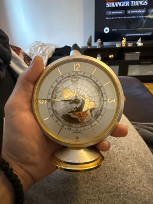 Bords klockan  - Bilderna visar en vintage bordsklocka i mässing med världskarta på urtavlan av guld 