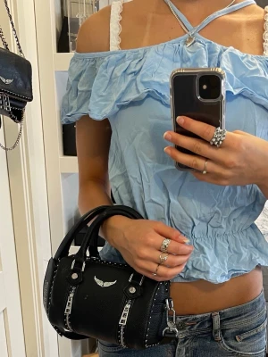 Offshulder blus - Supersöt ljusblå offshoulder topp från Little Remix med tunna axelband, volangdetaljer upptill och nertill och smock i midjan för en snygg passform. Passar XS/S.