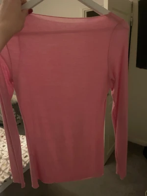 Ljusrosa långärmad topp - Säljer en ljusrosa långärmad topp med rund hals från intimissmi då den inte kommer till användning. Toppen är tunn och har en slim passform som sitter snyggt mot kroppen. Materialet känns mjukt och lätt mot huden.