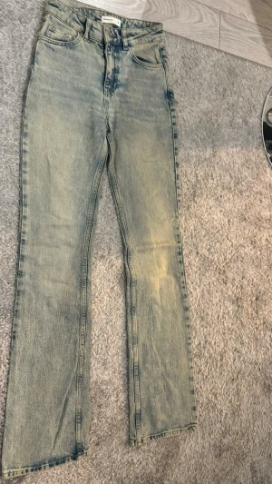 Perfekt Jeans ljusblå streat wear jeans  - Säljer ett par ljusblå jeans, yk2 style/ streat wear från Perfekt Jeans med klassisk femficksdesign och utsvängda ben. Jeansen har en snygg tvättad look och normal passform. Materialet är robust denim i bomull och de har låg midja för en schysst siluett.