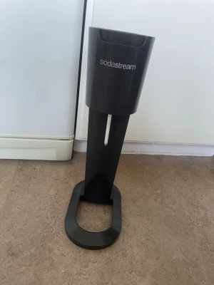 Ingen väst på bilderna - Bilderna visar en Sodastream-maskin i svart plast, inte en väst. Vänligen ladda upp bilder på en väst för att få en relevant beskrivning.