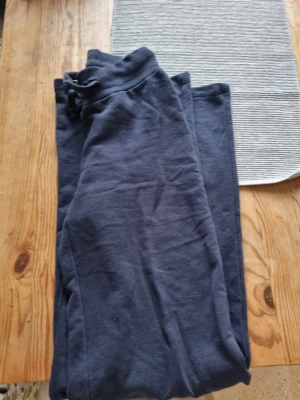 Mörkblå mjukisbyxor med snörning - Säljer ett par mörkblå mjukisbyxor med skön passform och snörning i midjan. Perfekta för chill dagar eller när du vill vara extra bekväm. Materialet är mjukt och känns riktigt nice mot huden.
