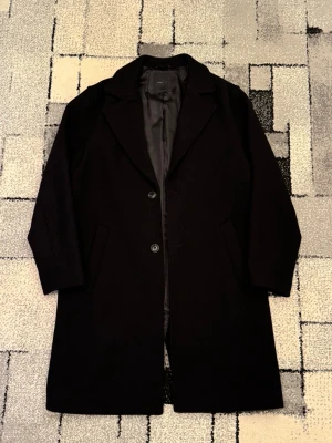 Svart Kappa från Pull&Bear - Klassisk svart kappa från Pull&Bear. Perfekt för dig som vill ha en stilren och tidlös look. Helt ny,aldrig använd. nypris 1000 kr. 