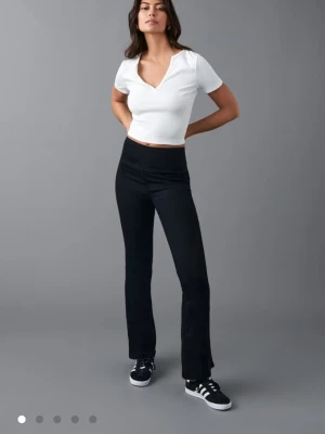 Svarta bootcut jeans med hög midja - Svarta byxor med bootcut-modell och hög midja. Snygg passform som sitter tajt över låren och släpper ut vid bensluten. Gjorda i ett stretchigt material som känns bekvämt hela dagen. Perfekta till sneakers eller boots.