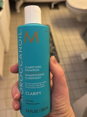 Moroccanoil Clarifying Shampoo 250ml - Säljer en Moroccanoil Clarifying Shampoo i en snygg turkos plastflaska med vitt lock. Flaskan innehåller 250 ml och är färgsäker. Perfekt för dig som vill få bort produktrester och ge håret en fräsch känsla.