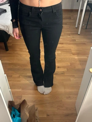 Svarta bootcut jeans från ONLY - Svarta jeans från ONLY i bootcut-modell med klassisk femficksdesign och knappstängning. Snyggt smal passform upptill som går ut lite vid bensluten. Perfekta att matcha med sneakers eller boots. Materialet är jeans med lite stretch för extra komfort.