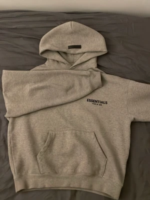 Essentials hoodie - Hoodien är en replika. Haft på mig ganska mycket. Storlek small men passar lite mindre. Har en svag fläck vid nackområdet, inget som kommer synas