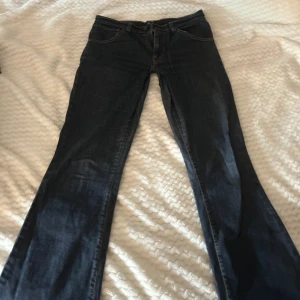 Levi's bootcut jeans mörkblå - Snygga mörkblå bootcut jeans från Levi's med klassisk femficksdesign och kontrastsömmar. De är även uppsydda så de är lägre i midjan. 37cm rakt över midjan. 85cm i innerbenslängd. 