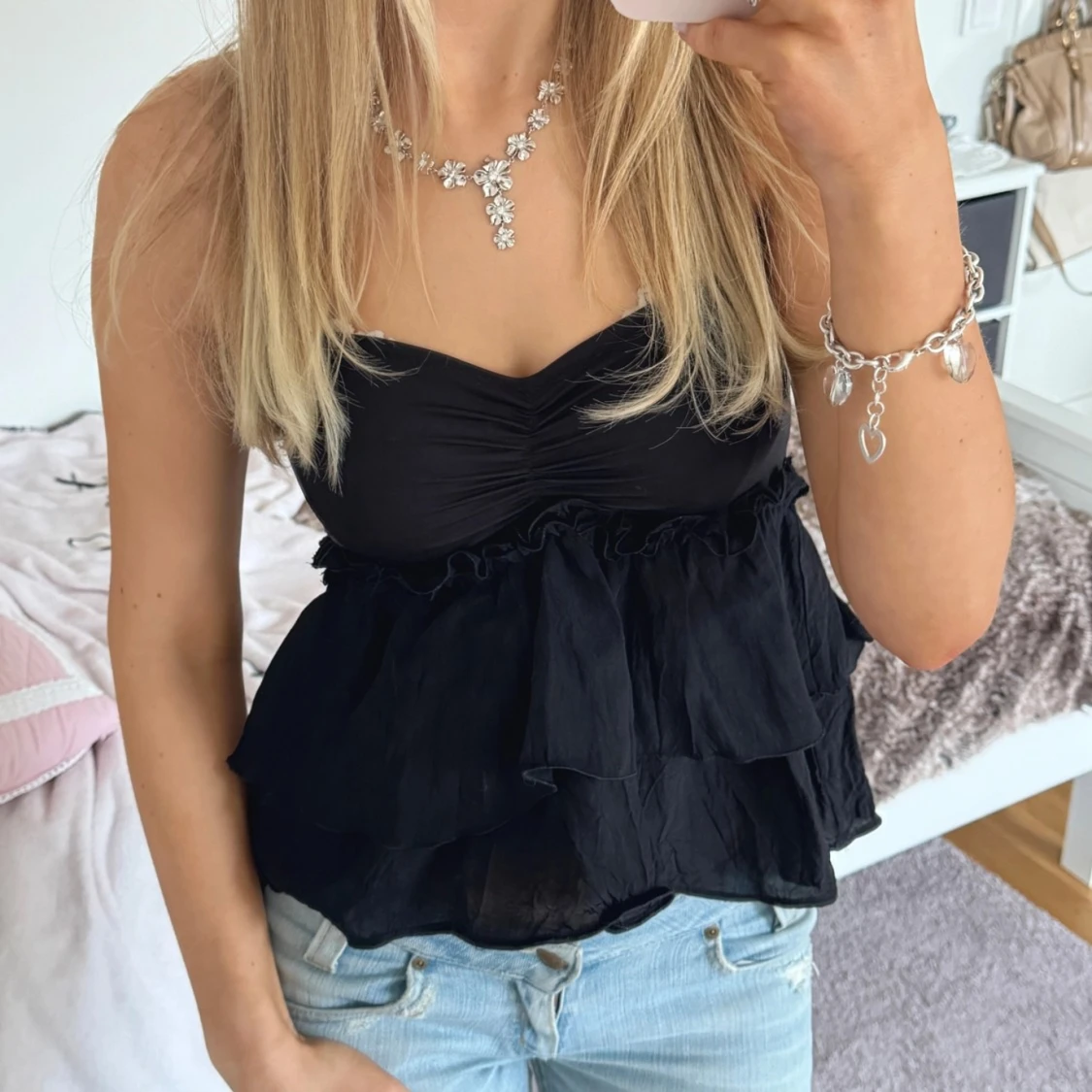 Svart axelbandslös topp med volanger