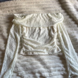 Off shoulder topp - Vit, långärmad topp med off-shoulder design och spetsdetaljer. Perfekt för en utekväll, ett speciellt tillfälle eller om du bara vill vara fin! Helt oanvänd, alltså toppen skick. Super gullig!💕