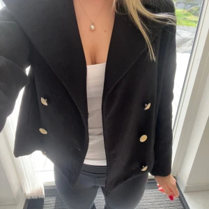 Svart kapp från Zadig Voltaire med guldknappar💞💞💞 - Svart kappa  från Zadig Voltaire  med guldknappar framtill och snygg broderad vingdetalj på ryggen. Jackan har en stilren look som passar perfekt till höst och vinter. Tillverkad i ullblandning för en varm känsla. Kappan är i storlek 16år/xs/s. Nypris 2200kr💞💞 