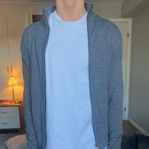 Grå merinoull kofta från These Glory Days - Säljer en stilren grå kofta från These Glory Days i mjuk och lyxig merinoull. Koftan har hel dragkedja framtill, hög krage och lång ärm. Perfekt för lager-på-lager och funkar året runt. Enkel att matcha med det mesta! Säljer den för att den har blivit för liten för mig! Nypris-1500kr/mitt pris-650kr