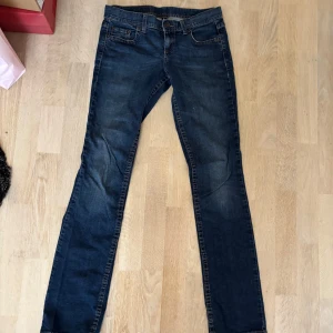 Blå Benetton jeans, straight fit, W27 - Snygga blå jeans från Benetton i klassisk straight fit. Jeansen har fem fickor, Benetton-logga på bakfickan och läderpatch bak i midjan. Mörkblå tvätt med lätt slitning och kontrastsömmar. Perfekta för en chill och stilren look. Storlek W27!🩷
