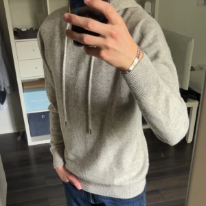 Ljusgrå Kashmir/Merinoull Hoodie S -  Tja, säljer min Ljusgrå hoodie i Merinoull/Kashmirblandning, storlek Small. ORIGINALPRIS: 650kr. Använd väldigt lite. Den är väldigt mjuk, skön, ganska varm och sjukt stilren och snygg. Så passar perfekt för dig som vill ha en ny snygg unik hoodie i höst. Hör av er vid frågor eller funderingar😁
