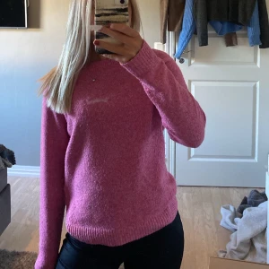 Rosa stickad tröja med rund hals - Mysig rosa stickad tröja med rundad hals och ribbade muddar vid ärmslut och nederkant. Tröjan har en enkel och clean look, perfekt att slänga på sig när det är lite kyligt. Långärmad och i en skön, mjuk kvalite🌸