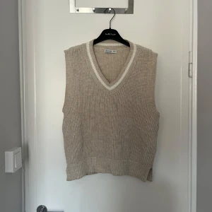 Beige stickad väst med v-ringning - Beige stickad väst från Stradivarius med  v-ringning. Använd ett fåtal gånger, storlek M!