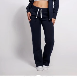 Mörkblå mjukisbyxor med snörning - Mörkblå mjukisbyxor med vit snörning i midjan och raka ben. Byxorna är från russemerch och är nya med prislapp har en bekväm passform och är tillverkade i mjukt material, perfekta för en chill och avslappnad stil.💗