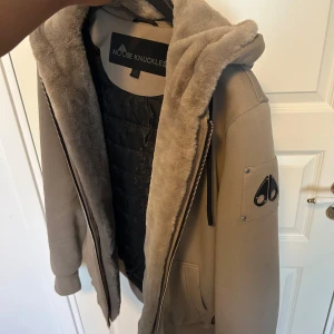 Moose Knuckles, Beige, XS - Säljer min Moose Knuckles jacka i färgen beige, storlek XS. Köpt förra året på Johnells, kvitto finns. Jackan är i mycket bra skick, som ny, och passar perfekt nu till höst och vinter.