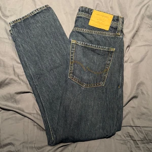 Blå jeans från Jack & Jones, 29/30 - Klassiska blå jeans från Jack & Jones med raka ben och snygga kontrastsömmar. Jeansen har inte används mycket och har inga slitningar eller missfärgningar . Perfekt passform(relaxed/chris) och tidlös stil som funkar till allt.