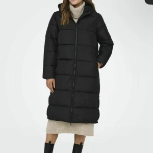 Svart lång pufferjacka med huva - Säljer en jätte fin vinterjacka, nästan identisk till den på bild. Använd några få gånger, precis som ny. Kom gärna privat för egna bilder! Köparen står för frakt.