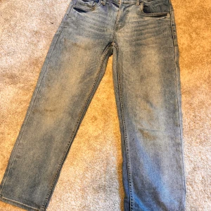 Levi's ljusblå jeans straight fit - Klassiska Levi's jeans i ljusblå tvätt med raka ben och normal passform. Jeansen har fem fickor, knappgylf och ikonisk läderpatch bak i midjan. Perfekta för en avslappnad och tidlös look. Jeansen är även i ett väldigt mjukt och skönt tyg.