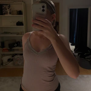 Ljuslila ribbad linnetopp med spets - Supersöt ljuslila ribbad linnetopp med smala axelband och v-ringning dekorerad med spetskant. Perfekt för lager-på-lager eller sommarens varma dagar. Sitter tight och har en feminin vibe.