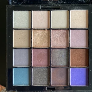 NYX Ultimate Shadow Palette Cool Neutrals - NYX Ultimate Shadow Palette i färgen Cool Neutrals USP02 med 16 nyanser. Paletten innehåller både matta och skimriga ögonskuggor i toner av beige, guld, lila, blått, brunt och grått. Perfekt för att skapa allt från naturliga till mer kreativa looks.