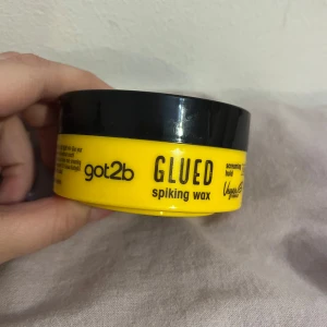 Got2b Glued Spiking Wax - Got2b Glued Spiking Wax i en rund, gul burk med svart lock. Vaxet är vitt och har en krämig konsistens, perfekt för att skapa spikiga frisyrer med extra stadga. Vegansk formula och ikonisk design som sticker ut i badrumsskåpet. Oanvänd 