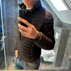 Svart dunjacka Colmar  - Säljer en svart dunjacka från Colmar. Jackan passar perfekt nu till hösten. Jackan är i storlek 48 vilket motsvarar en S. Jag är 188cm och den är lite kort på mig. Nypris ligger närmare 3000kr. Hör av er vid funderingar;)