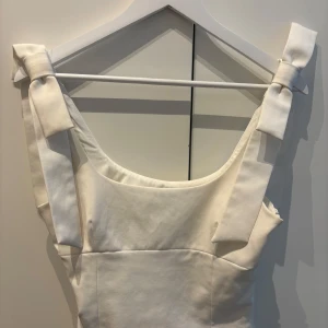 Vit topp från Zara - Supersöt vit topp från  Zara med axelband som knyts i rosetter. Sparsamt använd så inga fläckar eller liknande💕