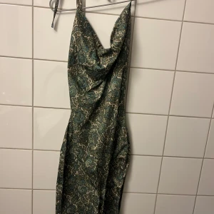 Grön mönstrad omlottklänning - Säljer en snygg grön klänning med blommigt mönster och omlott-detalj.🧚🏽🧚🏽🧚🏽🧚🏽