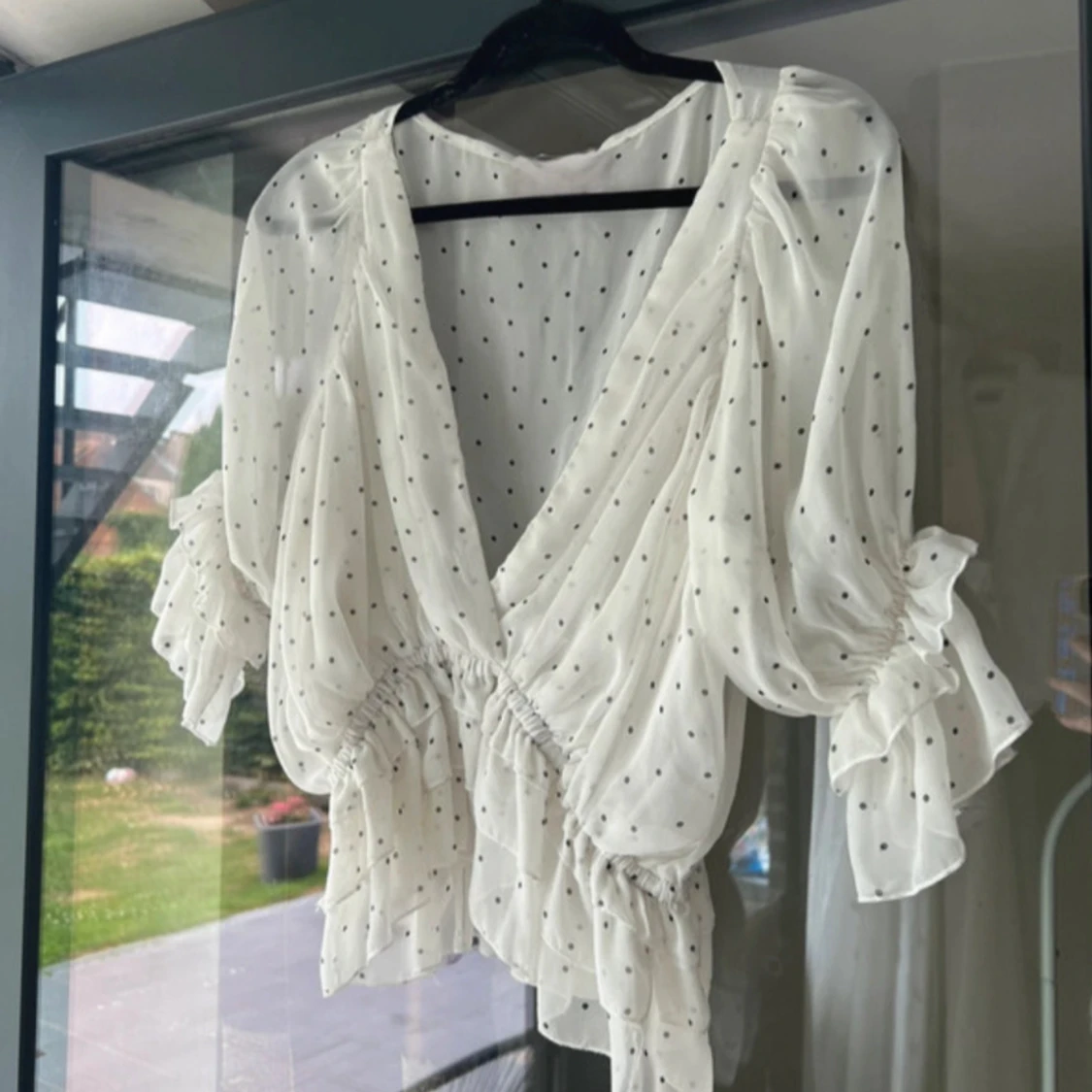 Vit prickig blus med volang