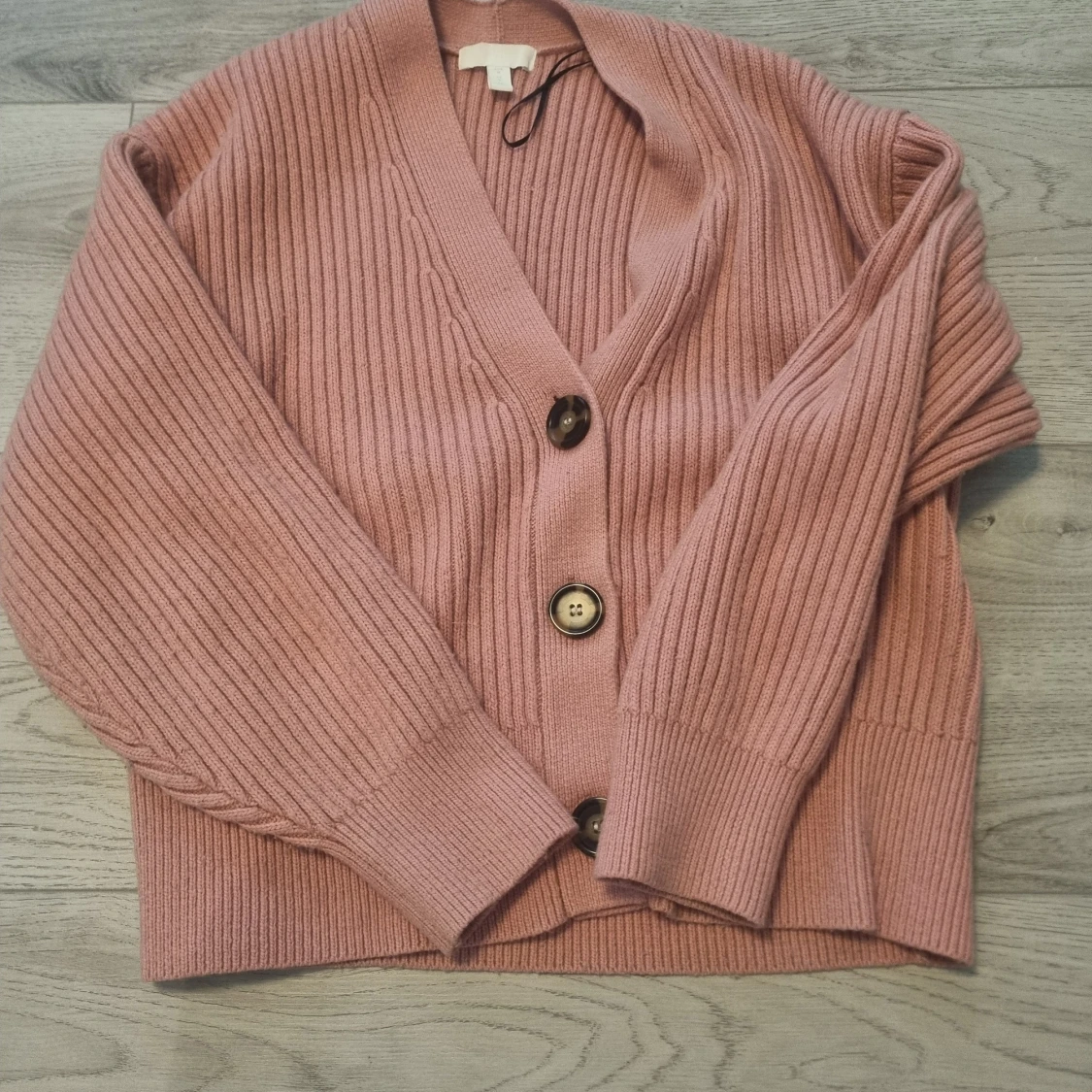 Rosa ribbad kofta med stora knappar