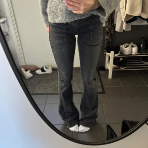 Svarta bootcut jeans med slitningar - Snygga svarta bootcut jeans med slitningar vid knäna och framsydda fickor. Jeansen har en lätt tvättad look och vida ben nertill. Säljer då jag tycker de är för långa på mig, storlek xs ”tall”💕💕yttepyttesmå slitningar längst ner vid kanten som inte syns när de är på, använda fåtal gånger