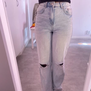 Ljusblå ripped jeans från FB Sister - Säljer ett par ljusblå jeans från FB Sister i storlek S. De är högmidjade med raka ben och har slitna hål på båda knäna för en cool, avslappnad vibe. Klassisk femficksmodell och tillverkade i bomull. Perfekta för dig som gillar en trendig och bekväm stil.