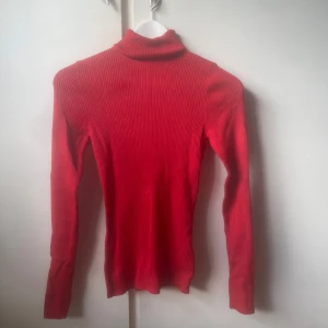 Röd ribbad polotröja med lång ärm - Säljer en tight röd polotröja med ribbat material och lång ärm. Använd endast 1 gång då jag skulle ha den till julafton och inte använt sen dess🥰Tror att den är från New Yorker men inte säker på storlek men xs/s ungefär 💕