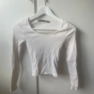 Vit ribbad långärmad topp 157 - Säljer en vit långärmad topp från 157 i storlek XS/S. Toppen är ribbad med rund halsringning och har en slimmad passform, passar till det mesta🥰