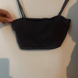 Grå croppad linnetopp - Väldigt kort magtröja. Grå (ljusare än på bilden). Perfekt att ha under en tröja man tycker är för urringad. 