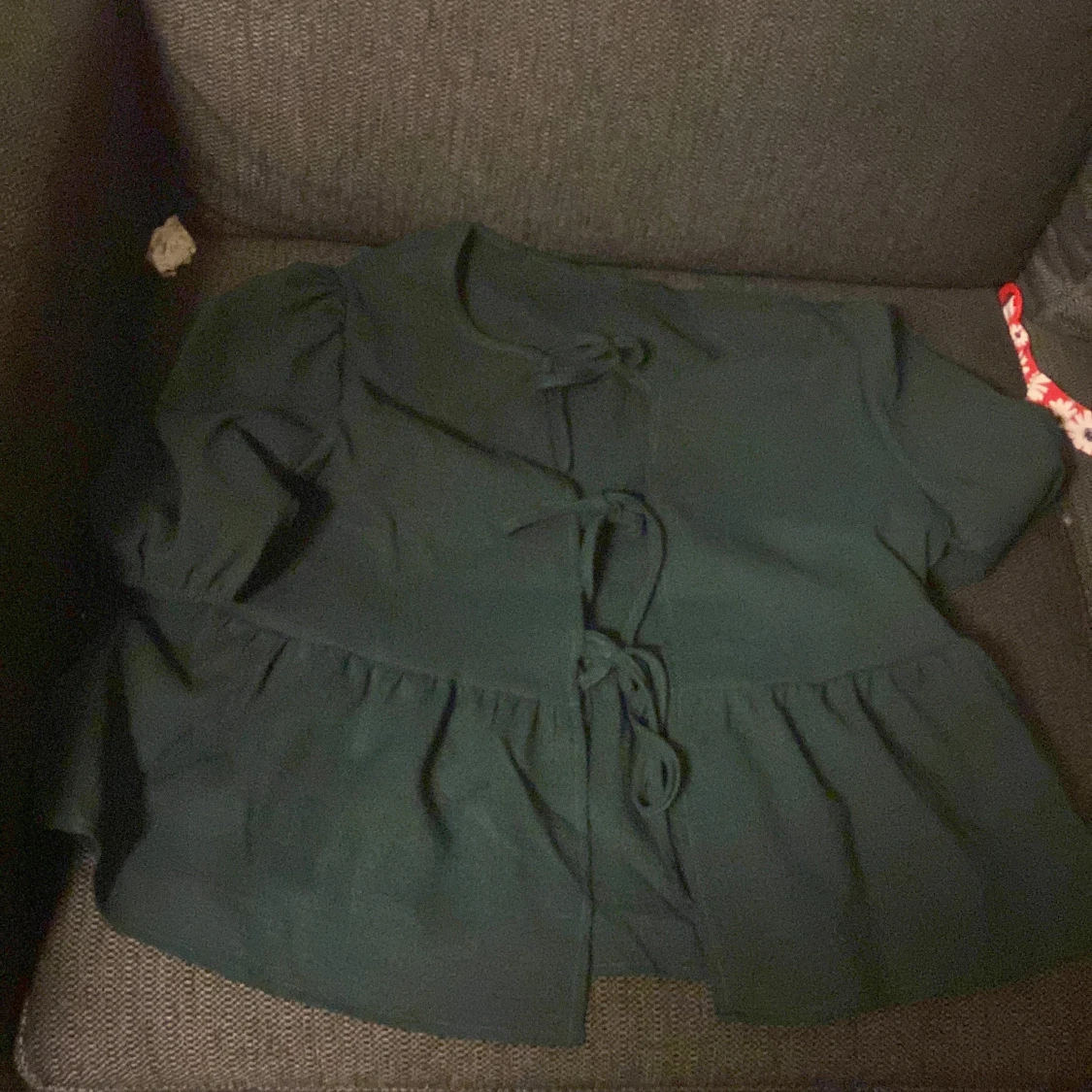 Mörkgrön blus med knyt och volang