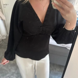 Svart blus med v-ringning från Neo Noir - Säljer en svart blus från Neo Noir med djup v-ringning och rynkade detaljer framtill. Helt oanvänd och nypris är 749 kr💕pris kan diskuteras