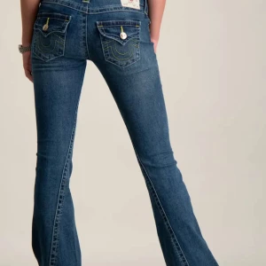 True religion jeans (joey) - (EJ MINA BILDER) (kan sänka pris)Snygga blå jeans med bootcut passform och markerade fickor bak med dekorativa sömmar och knappar. Jeansen har klassisk femficksdesign, gylf med dragkedja och bältehällor. Perfekta för dig som gillar en retroinspirerad look.
